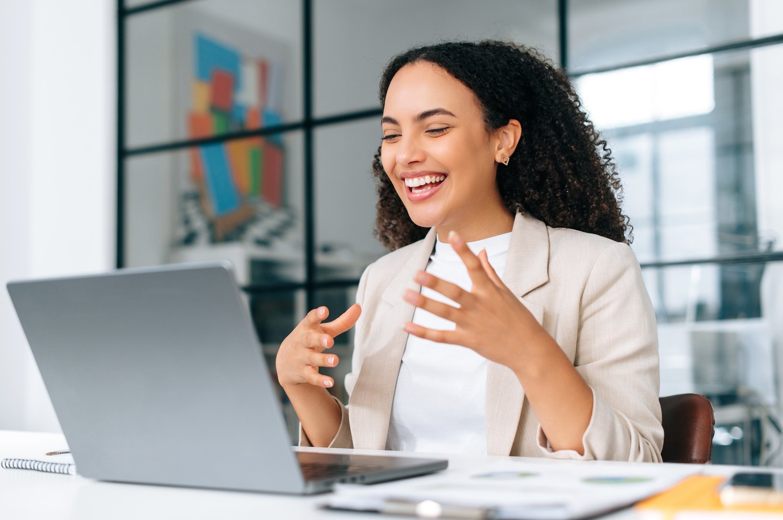 Excited emotional curly haired hispanic young business woman in stylish elegant clothes, team lead