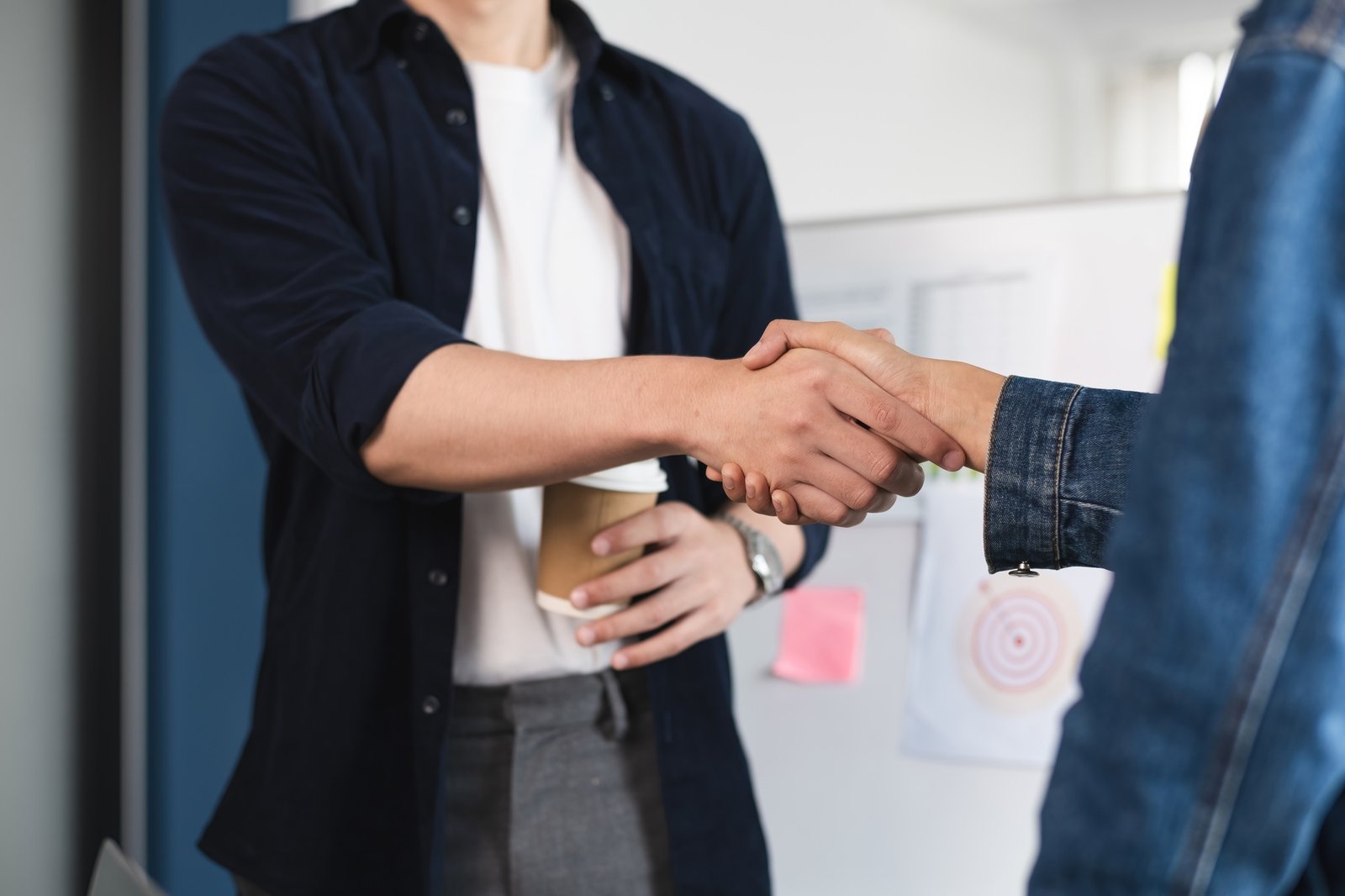 Two people shaking hands in a business setting. Concept of professionalism